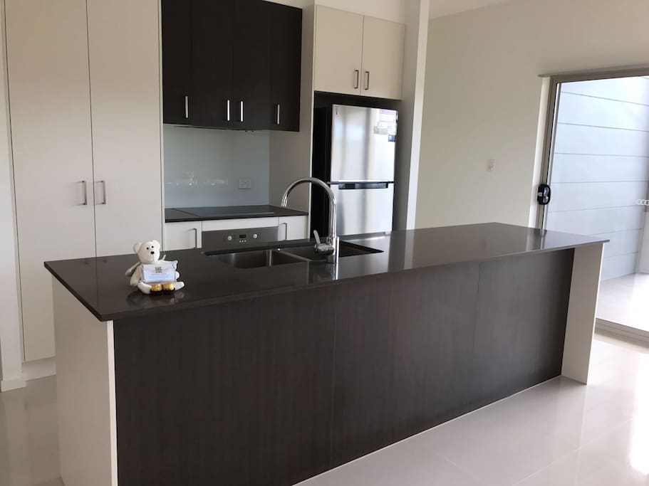 Kitchen with microwave, fridge, dish washing machine, stove, kettle, toaster and frypan