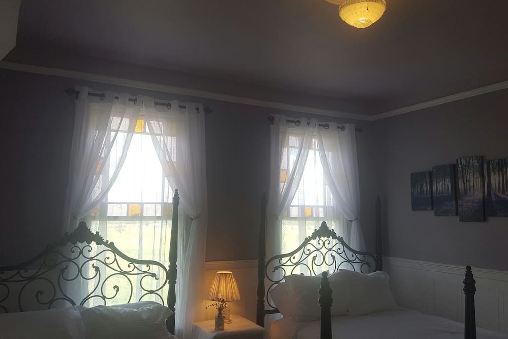 Two wrought iron queen beds with Northern window exposure.