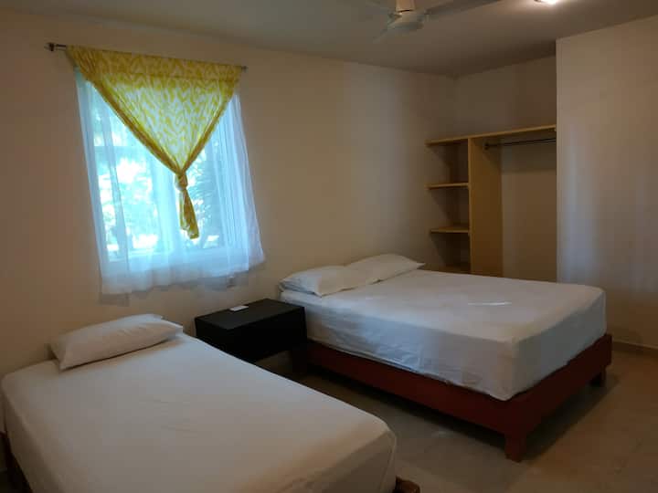 Habitación planta baja con una cama matrimonial y una individual. Baño completo. Aún no cuenta con clima, sólo ventilador de techo.