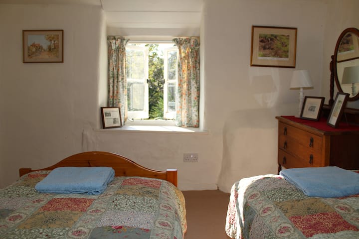 Bedroom with two single beds. View onto the private garden.  