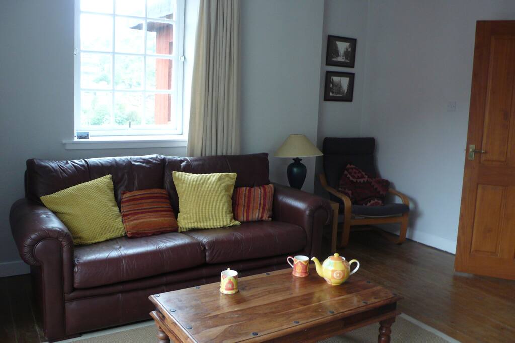 The living room has a sofa, easy chair and a Juliet balcony overlooking the Old Town