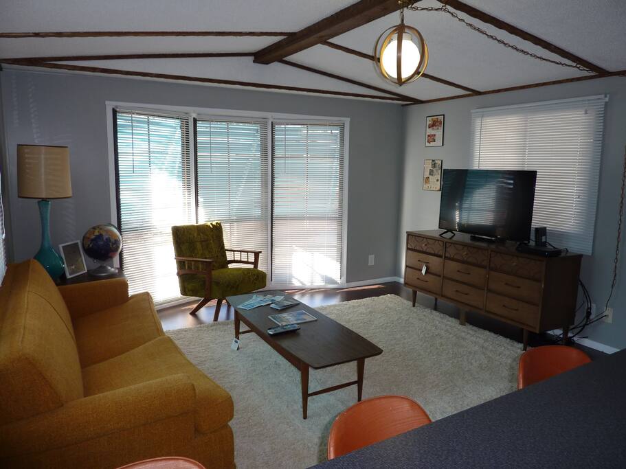 Living room with vintage furniture, sleeper sofa, flat screen TV and internet.