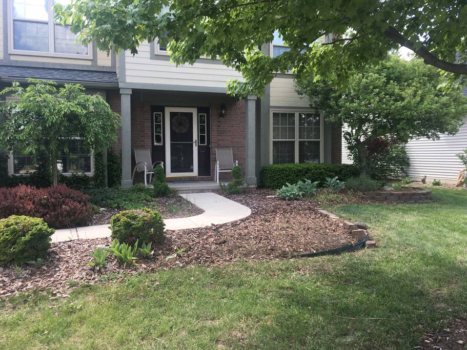 Covered front porch with two seats.