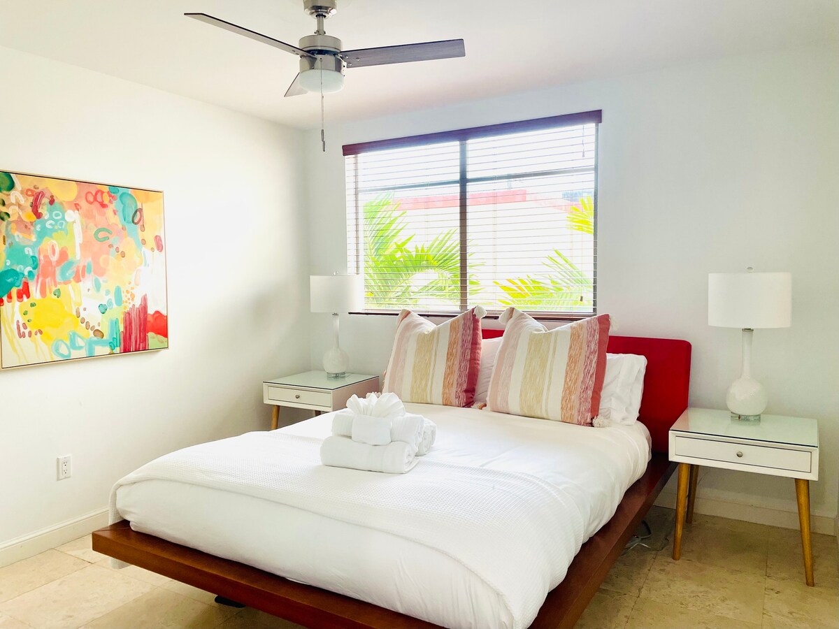 Spavaća soba s bračnim krevetom na 2. katu. Sunčeva svjetlost i palme u svakom prozoru.