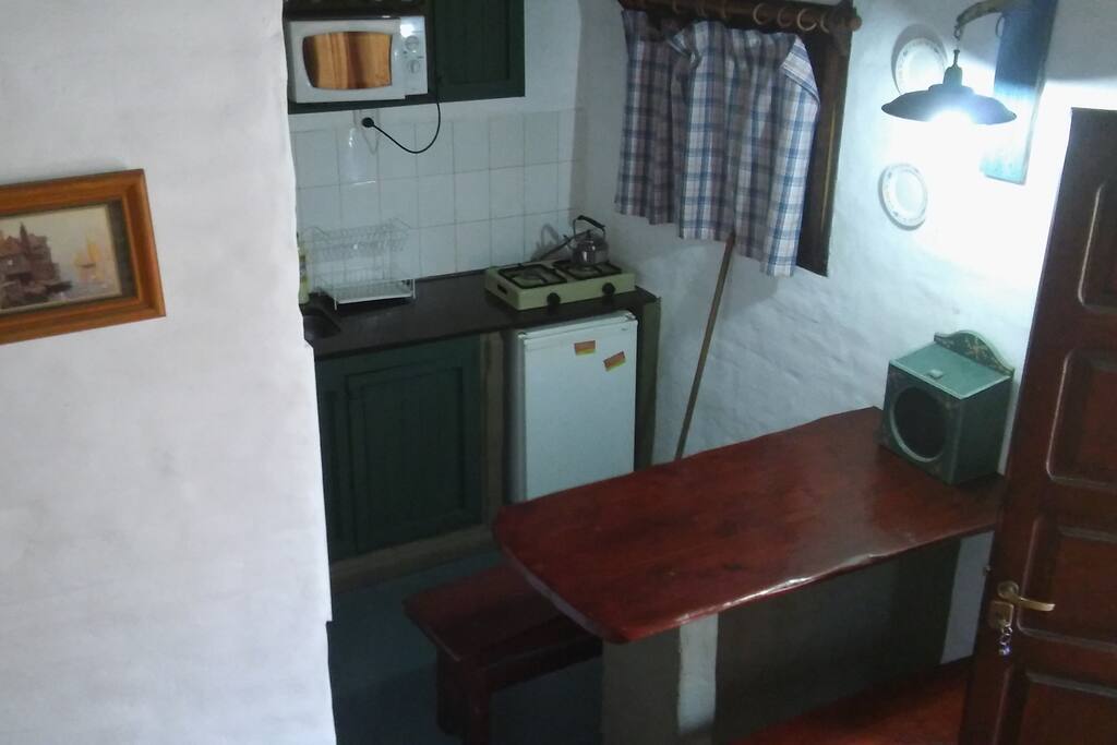 kitchenette y mesa con bancos para comer