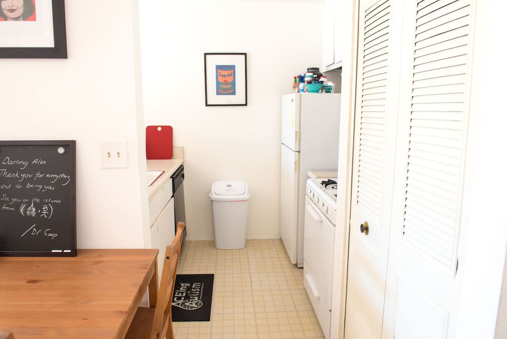 Kitchen, cooker, fridge, dining table.