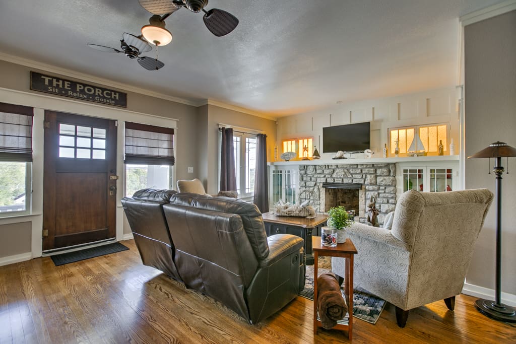 Charming living area, stone fireplace, hardwood floors, comfortable reclining leather couch