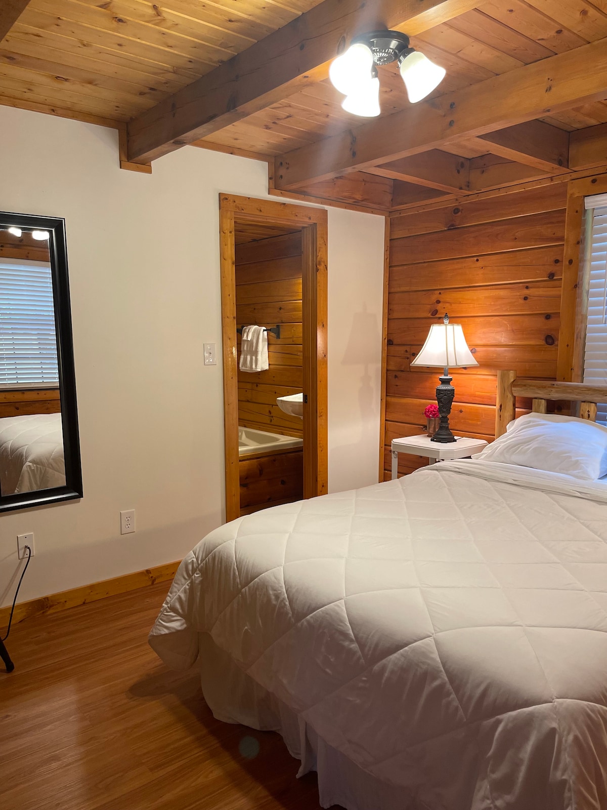 חדר שינה ראשי עם מיטת קווין סייז וחדר רחצה נפרד.