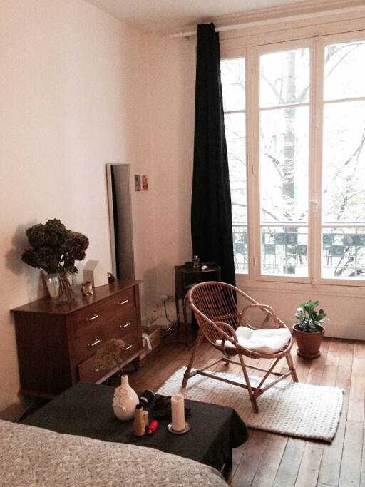 Chambre avec fauteuil et grande fenêtre