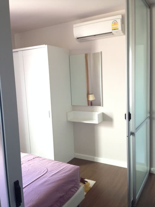 The bedroom have single bed, wardrobe, dressing table with a mirror, and air conditioner.
