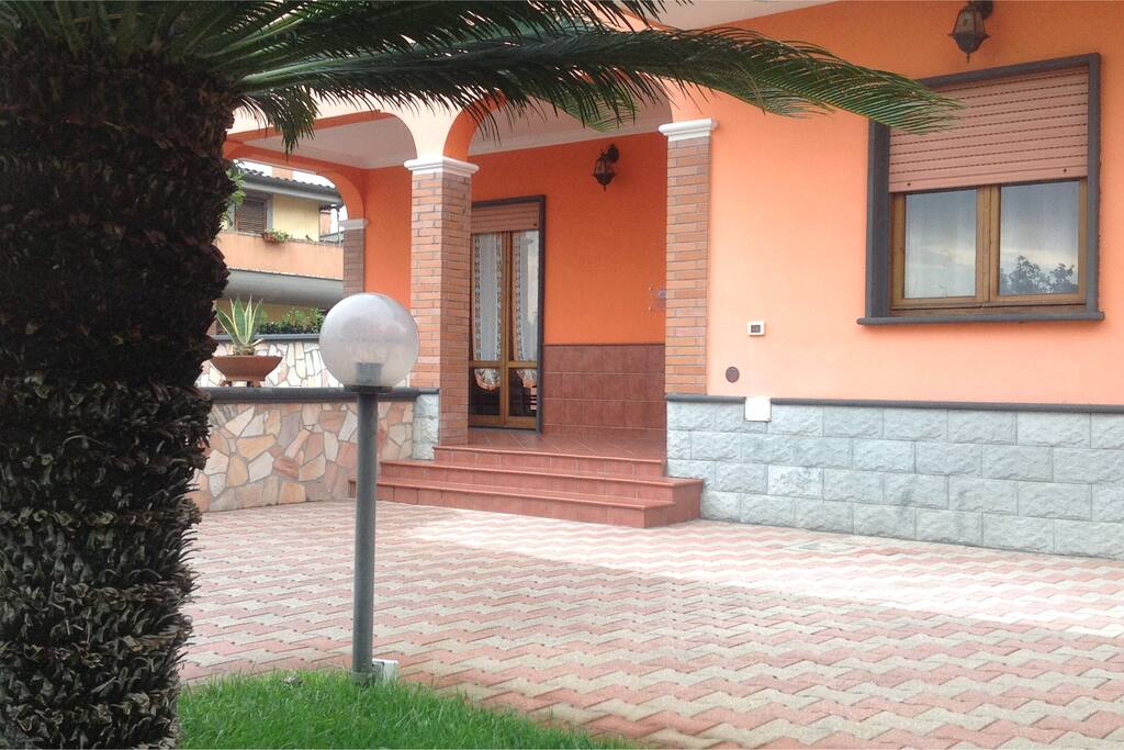 Visuale laterale della casa con vista porzione di giardino anteriore.-