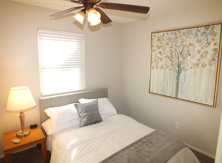 ห้องนอนที่ 4 พร้อมพัดลมเพดานเตียงคู่และชั้นวางกระเป๋าเดินทาง 