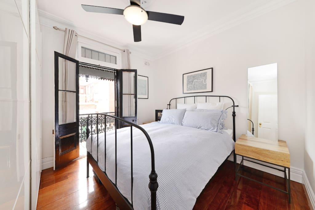 Master bedroom with balcony and queen size bed.