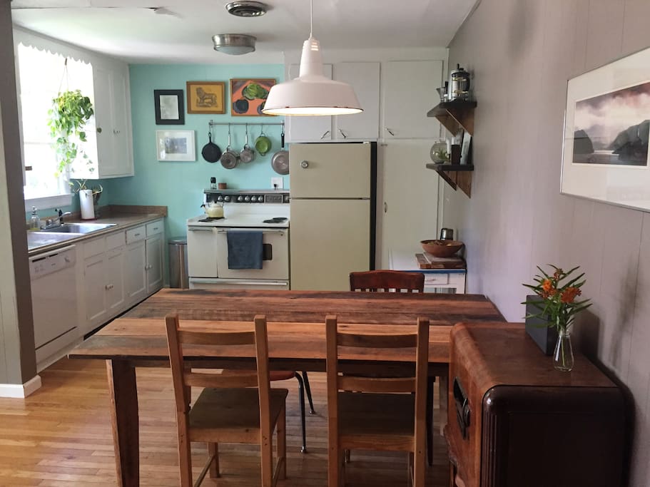 A lovely bright kitchen with wood floors and a farm table.