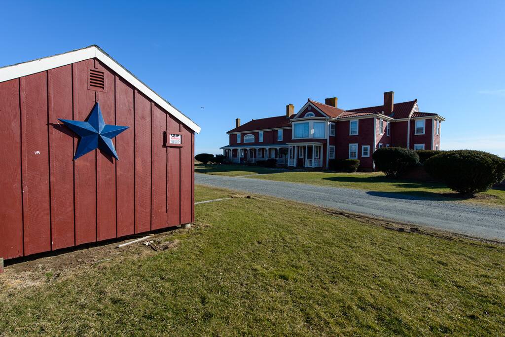Storage shed for bicycles, sports items, etc, then driveway, main house in distance, ocean beyond.