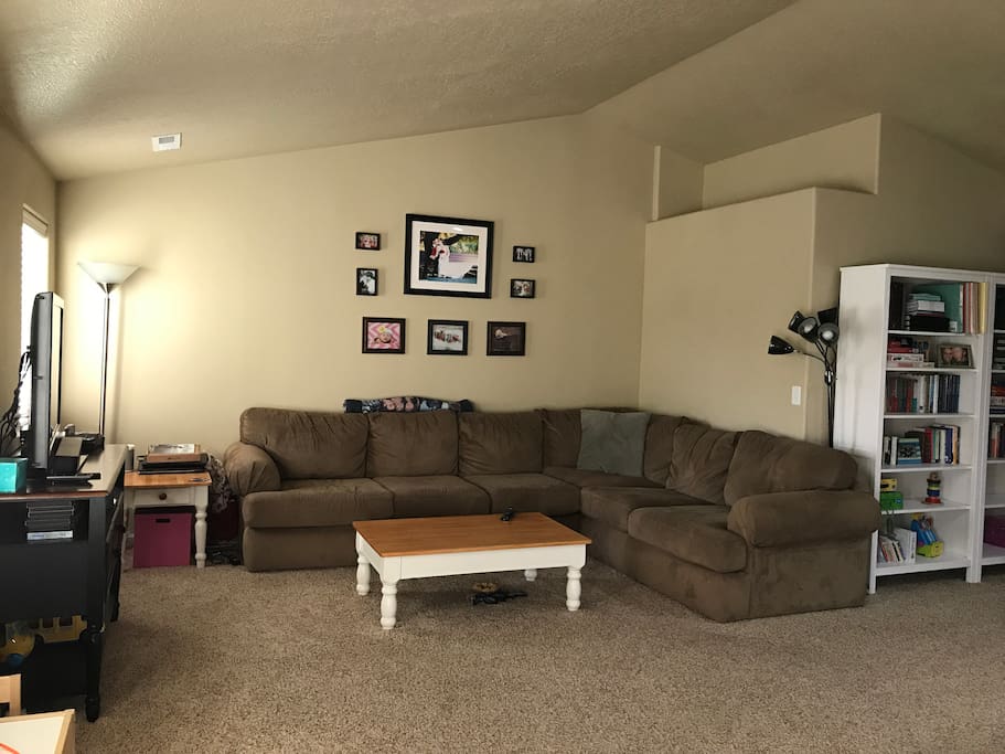 Living room with large sectional couch, TV, room for air mattress