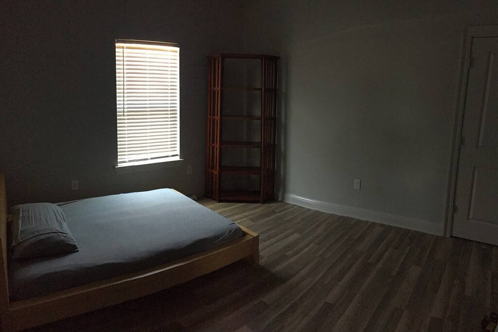 Spacious middle bedroom with platform bed and closet.