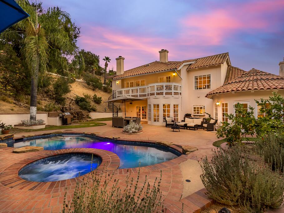 Another twilight view of the backyard. The pool and jacuzzi are lit with beautiful changing colored lights.
