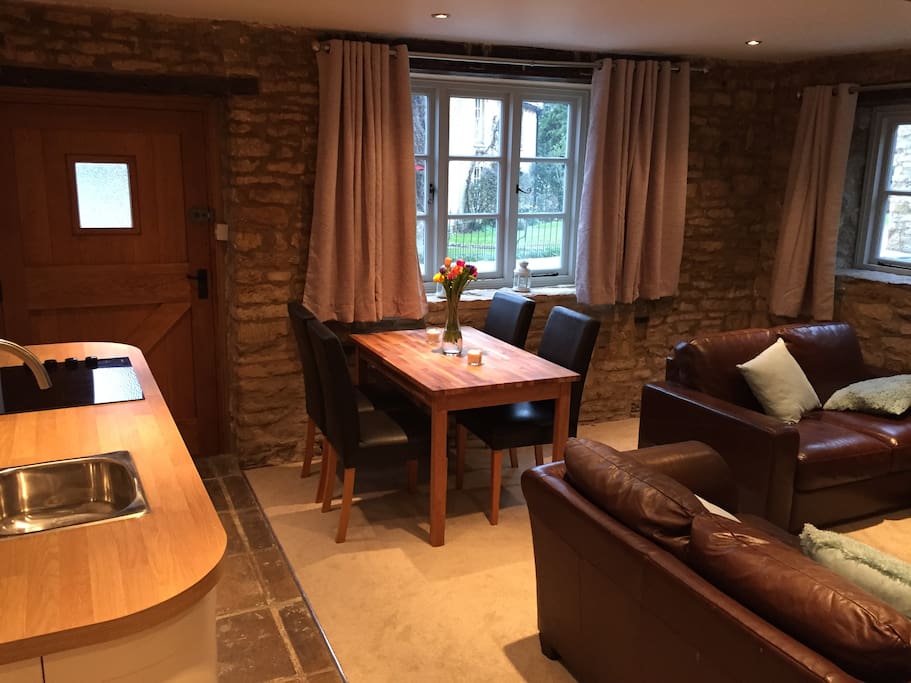 Front door with kitchenette, dining table and sofas
