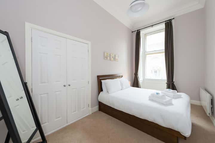 Deuxième chambre avec lit double, grande armoire intégrée et triple vitrage.