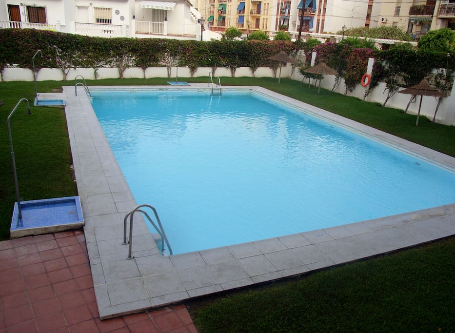 Piscina comunitaria con jardines