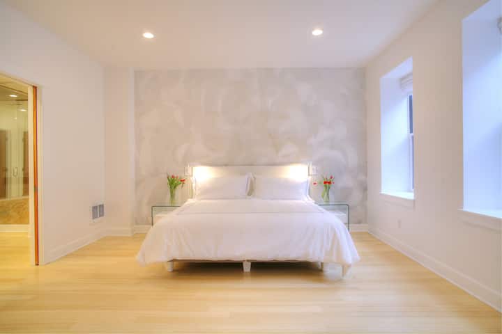 Chumba kikubwa cha kulala kina mural kutoka kwa msanii wa NZ Banker, mashuka ya Kiitaliano.