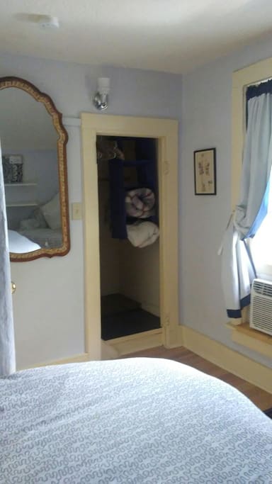 West facing 2nd floor bedroom, with Queen size bed, comfortable chair, small desk area and ample closet space. Window air conditioner.