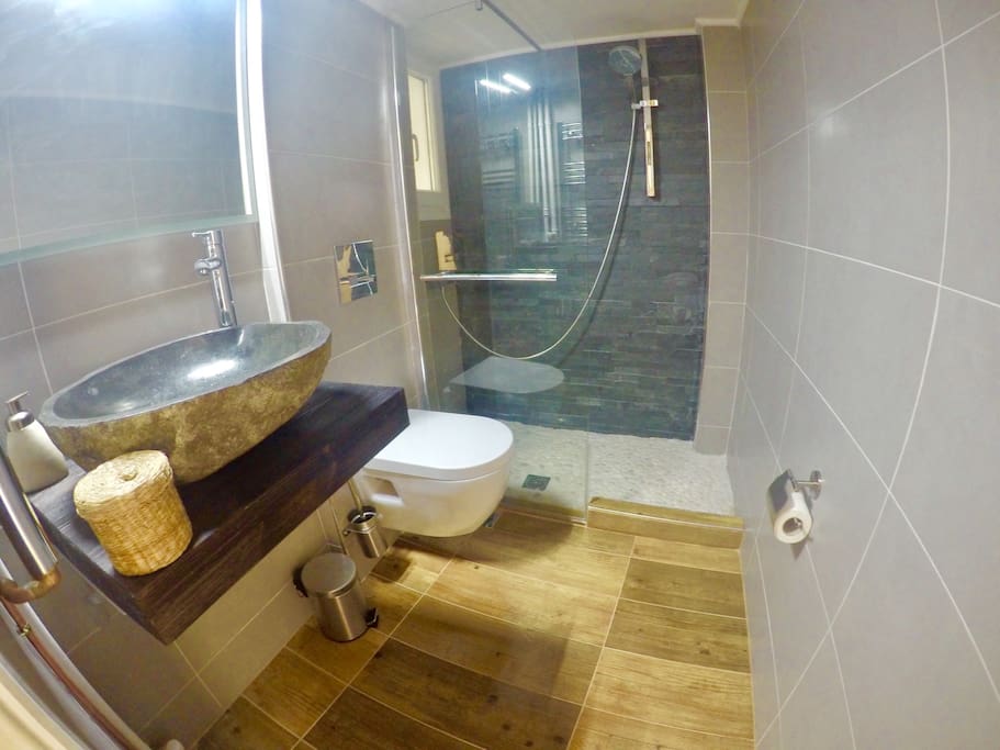 Enjoy a relaxing shower in the elegant bathroom. The main elements here are wood and stones.