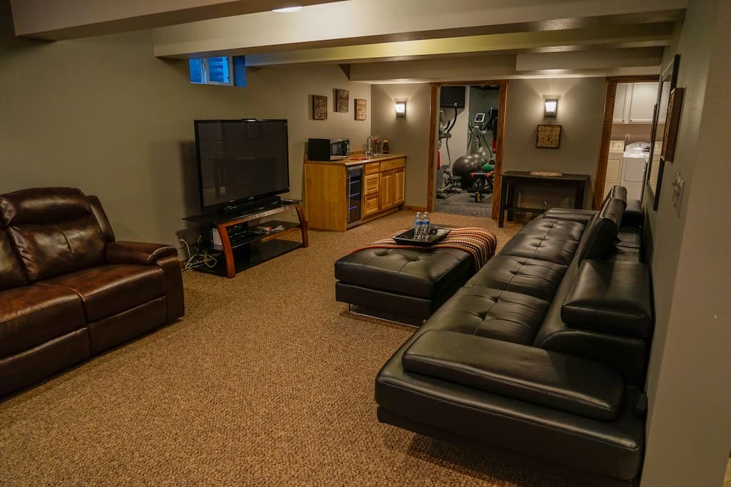 Living room features a large screen tv, wet bar & work station.