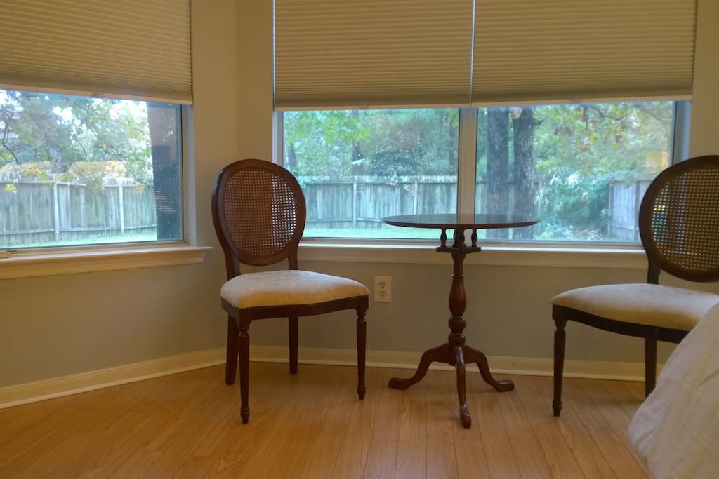 There is a bay window with a small sitting area in the room.