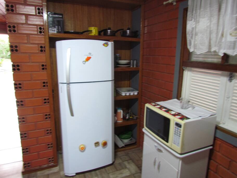 Geladeira, microondas e utensílios domésticos da Cozinha.