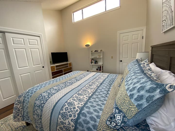 Light, Bright, and Relaxing Master bedroom with queen bed, 43 inch smart tv, dresser, and closet.