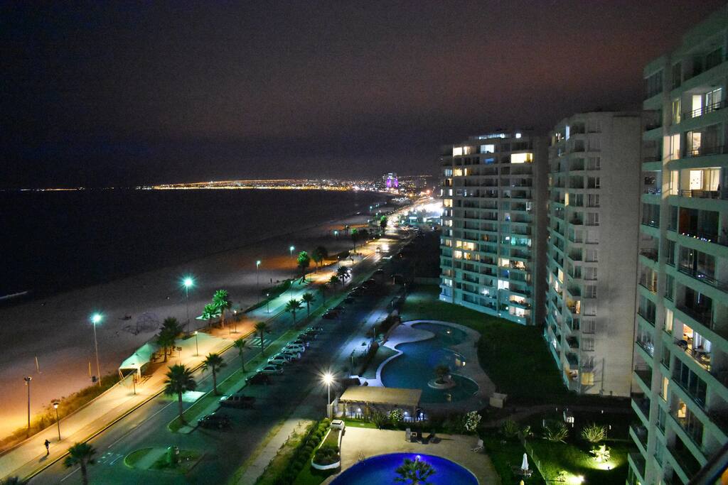Vista nocturna del departamento, se ve Av. Costanera, piscina y playa. De fondo, La Serena