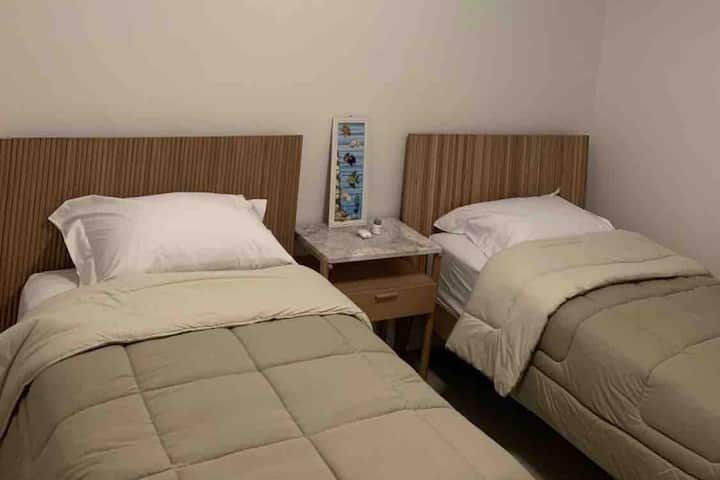 Bedroom 2, with two single beds, built-in closet, balcony, ceiling fan and digital split air conditioning.