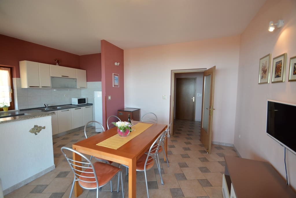 Kitchen with dinning table, and Tv place.