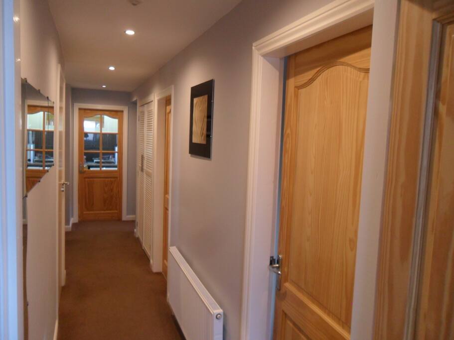 Main hallway with doors to all rooms and dining area