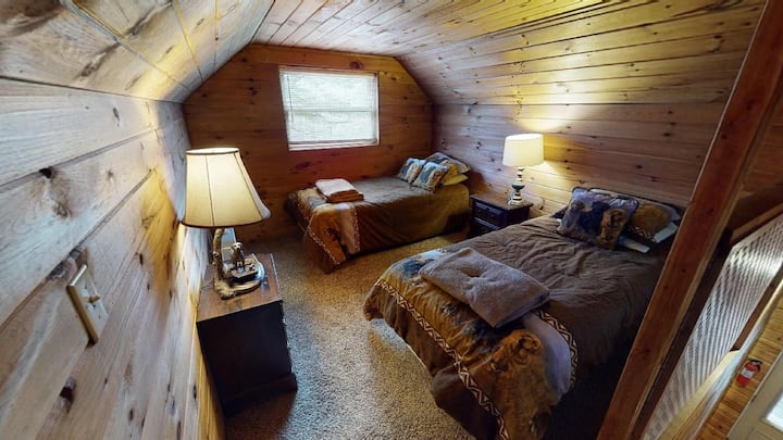 Hawk 's Nest Cabin Bedroom 3 peut accueillir confortablement 2 personnes avec 2 lits jumeaux situés dans une chambre surélevée.