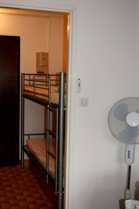 Coin entrée séparé par une porte avec les lits supperposés