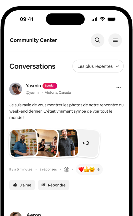 Un téléphone affiche un fil de conversations avec une publication photo d'un hôte et les réactions de la communauté.