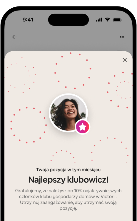 Telefon, na którym widać okno z okazji wyróżnienia najlepszego klubowicza, w którym znajduje się awatar gospodarza i odznaka rangi.