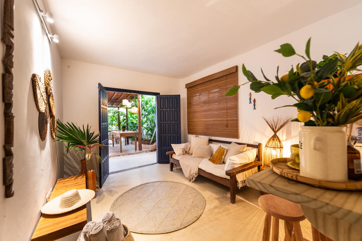 Sala da Casa Maruê com portas azuis abertas para o deck