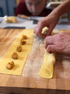 Prepara pasta italiana en una cocina local
