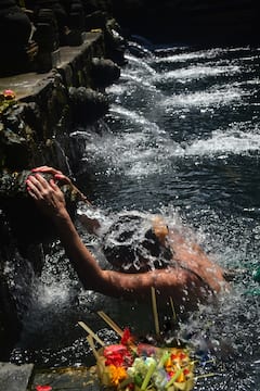 与当地人一起在巴厘岛的圣水中净化身心。