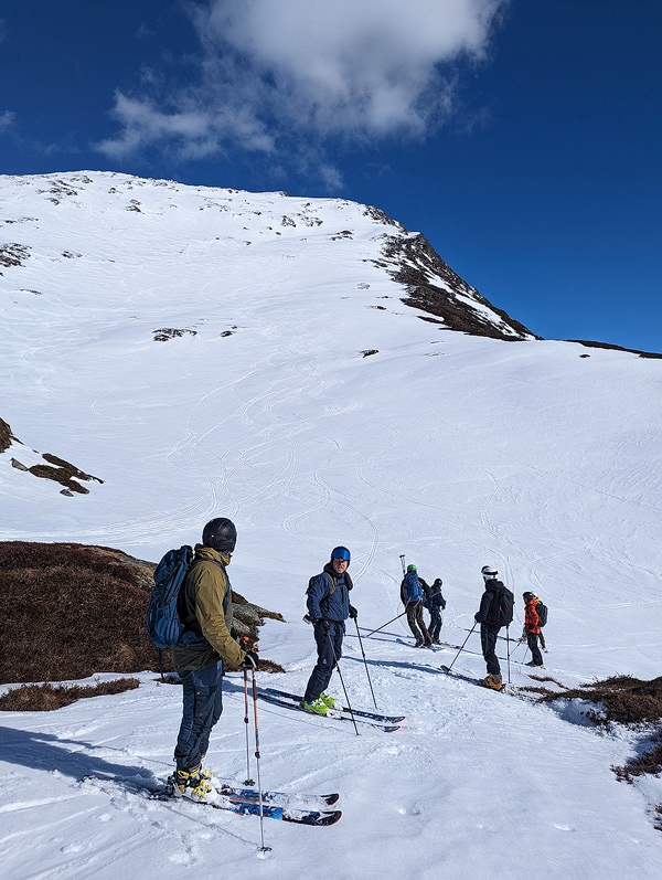 Winter mountain with skis/snowshoes and fjord views