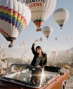 Expérience en voiture d'époque au lever du soleil avec des ballons