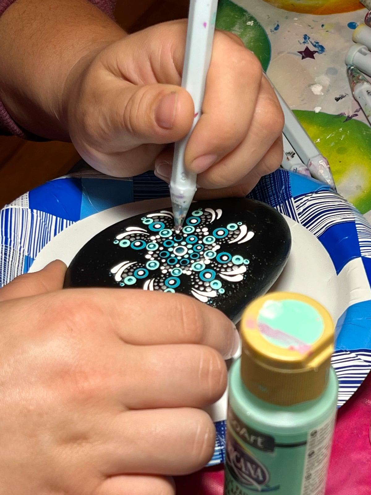 Dotting mandalas on rocks with an artist