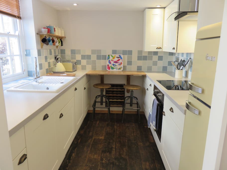 Fully fitted kitchen with breakfast bar & two stools.