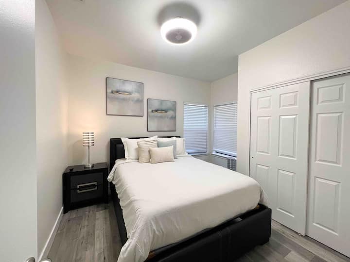 ห้องนอนแขกพร้อมเตียงขนาดควีนไซส์สมาร์ททีวีและตู้เสื้อผ้า