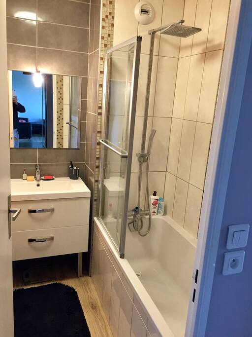 Salle de bain avec baignoire et paroi de douche