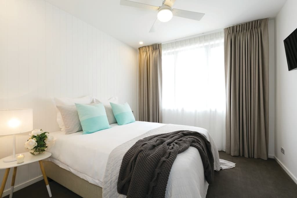 Spacious, inviting Queen size bed with luxurious linen and premium bedding.